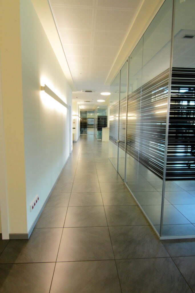 Corridoio con pareti in vetro e spazi luminosi – DB Electronics