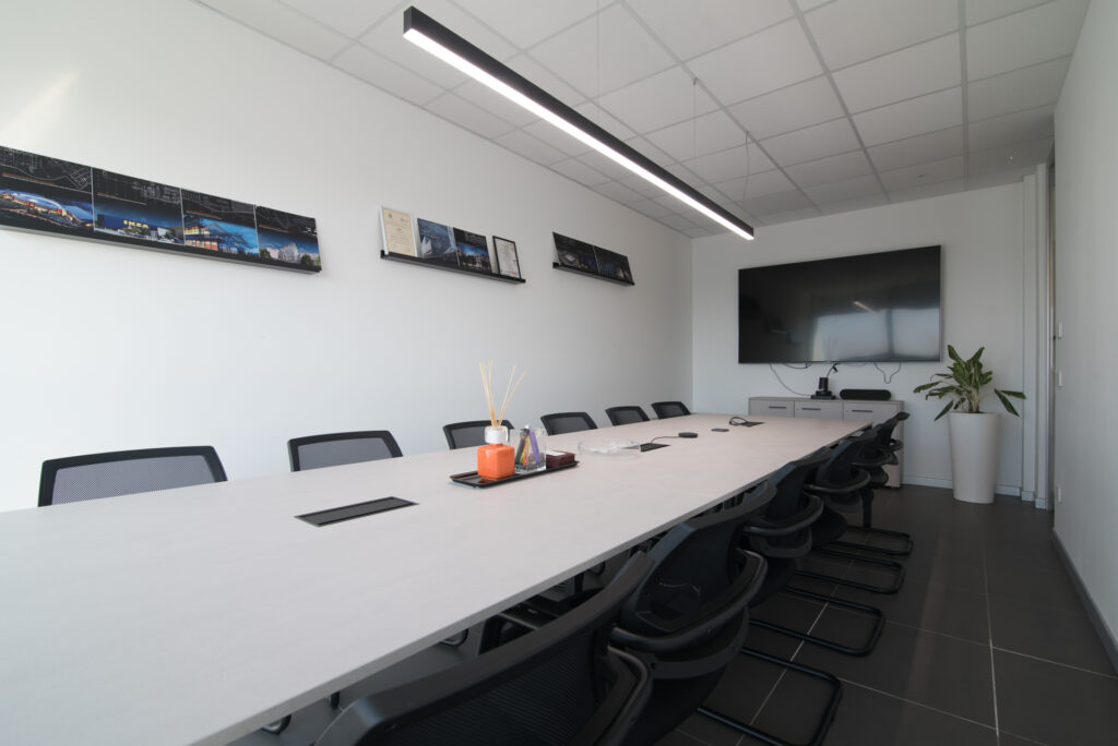 Sala meeting con tavolo condiviso e luce lineare – Kite Engineering