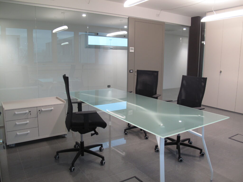 Sala riunioni con tavolo in vetro e pareti divisorie – Povelato